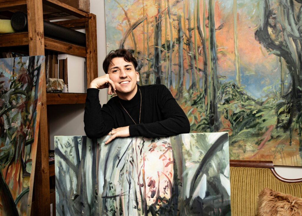 Thomas Flynn Studio Image of Thomas Flynn in his studio surrounded by large colorful artworks.