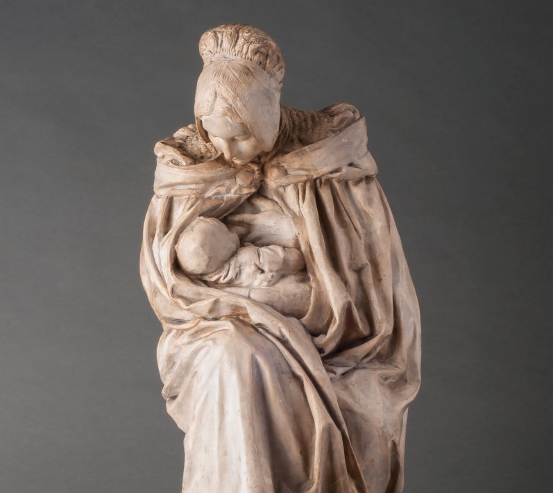 Terracotta sculpture of a woman nursing her child.