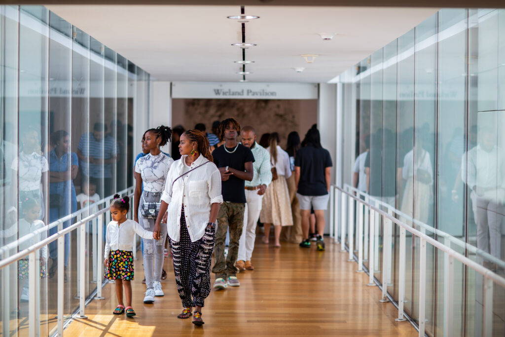Eve 2023 09 09 Secondsunday 145 Group of individuals walking through a bright glass hallway.