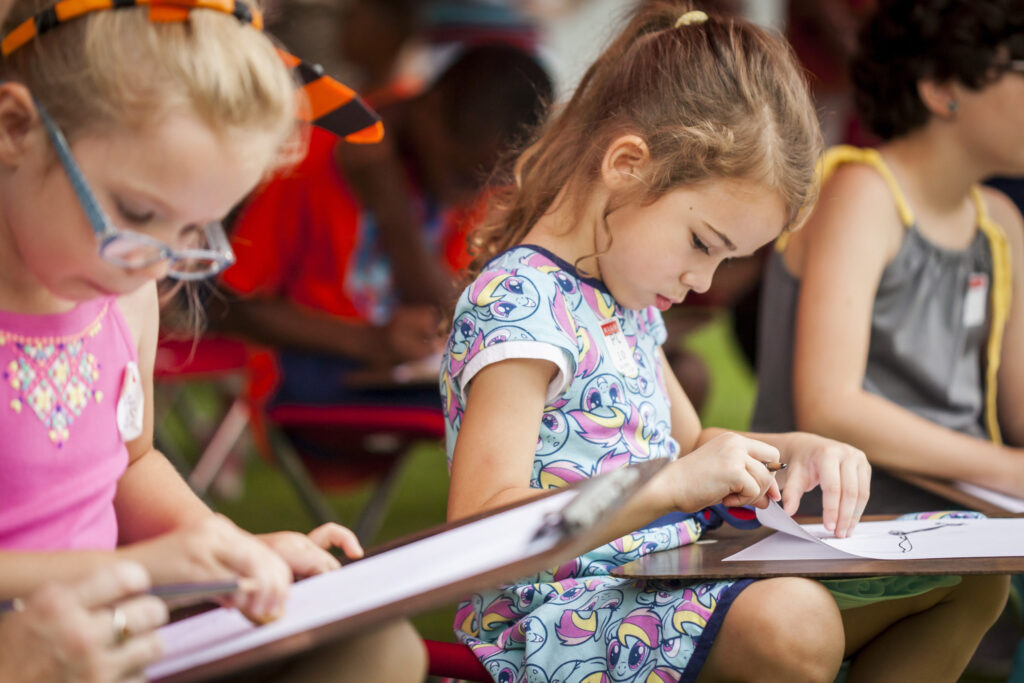 young girls making a drawing.