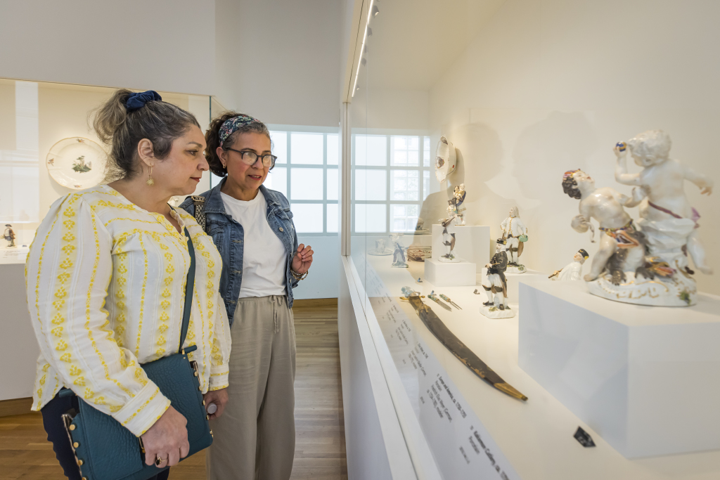 Two individuals looking at artworks through a display.